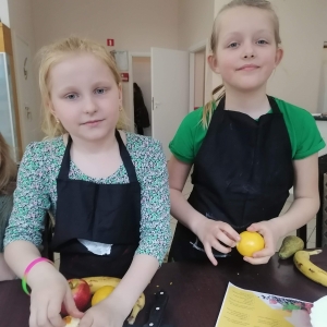 Dziewczynki przygotowują owoce do wyciśnięcia soku