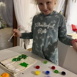 dziewczynka maluje worek farbami do tkanin