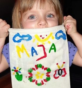 dziewczynka pokazuje własnoręcznie pomalowany worek